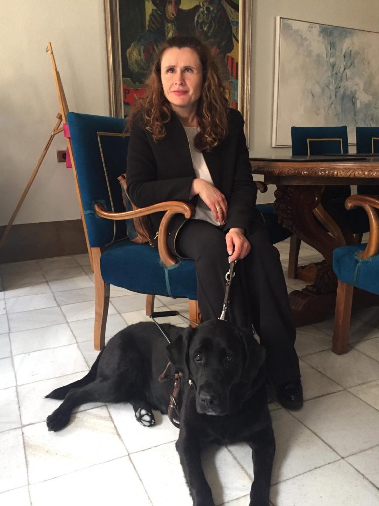 Presidenta asociación Perro guías Murcia sentada en el ayuntamiento de Cieza con Alma su perra guia